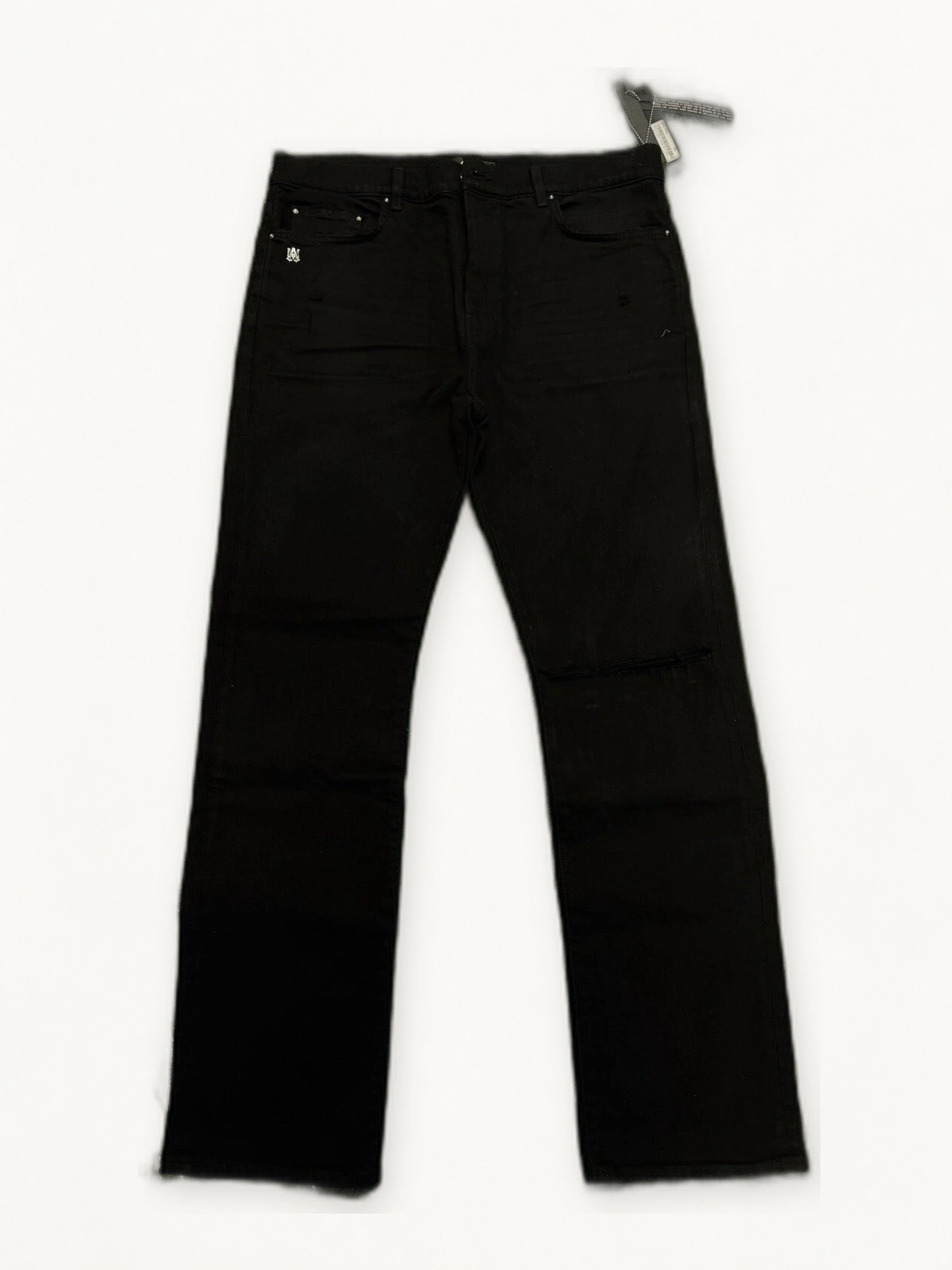Amiri black five pocket jeans on warm off white studio background