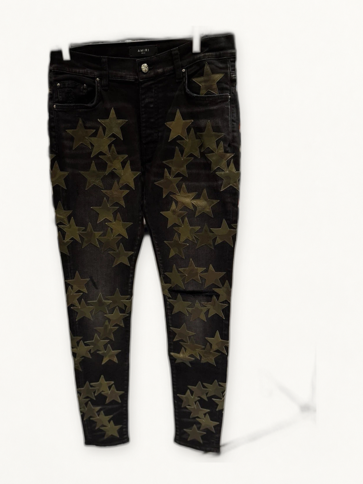 Amiri Chemist black green jeans on warm off white studio background