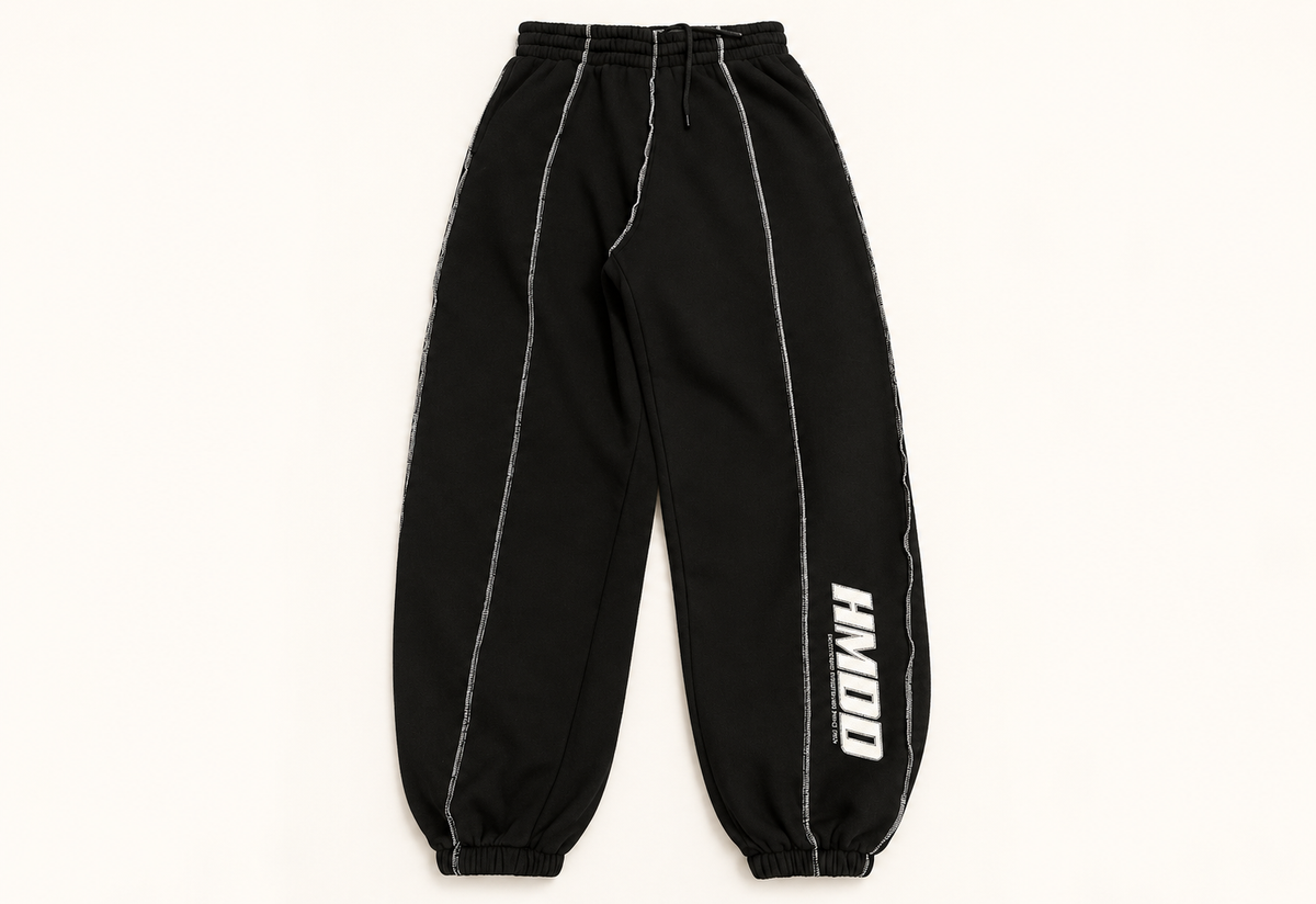 HMDD Chimp black sweatpants on warm off-white studio background